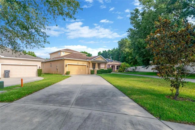 a front view of a house with yard and green space