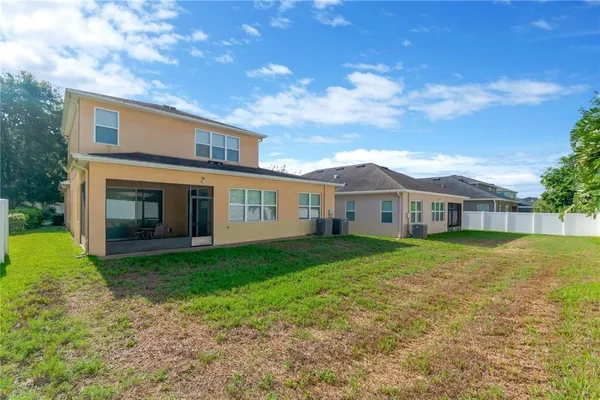 a view of a yard in front of a house with large trees