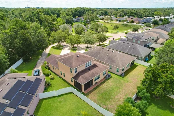 an aerial view of a house with garden space and a lake view