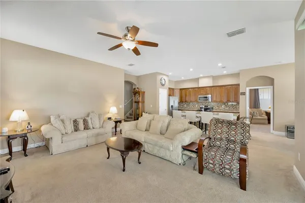 a living room with furniture and a view of kitchen