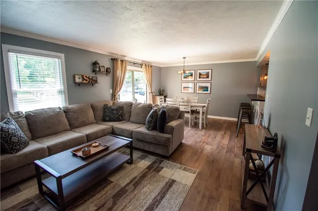 a living room with furniture a wooden floor and a window