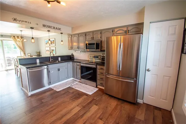 a kitchen with stainless steel appliances granite countertop a refrigerator and a stove top oven