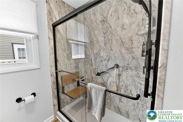 a bathroom with a granite countertop shower and a mirror