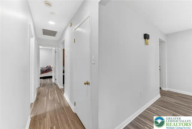 a view of a hallway with wooden floor and staircase