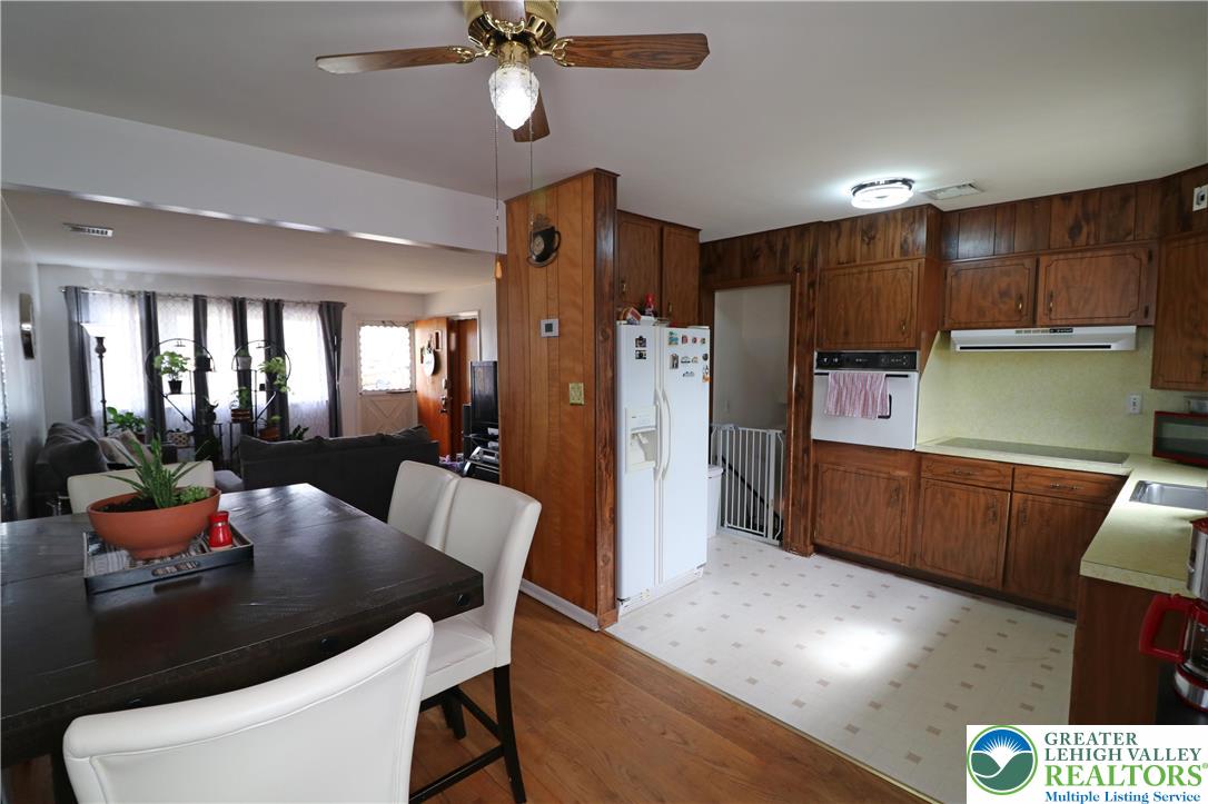 1022 Hilton Street Bethlehem, PA 18017 - Photo 7 of 35 a kitchen with stainless steel appliances kitchen island granite countertop a refrigerator a stove top oven a dining table and chairs with wooden floor