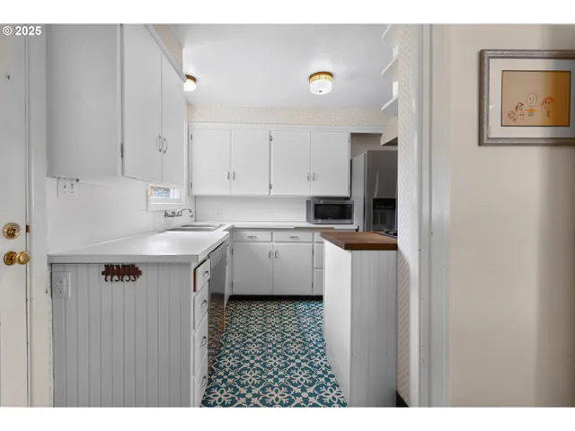 a kitchen with kitchen island a sink stainless steel appliances and cabinets