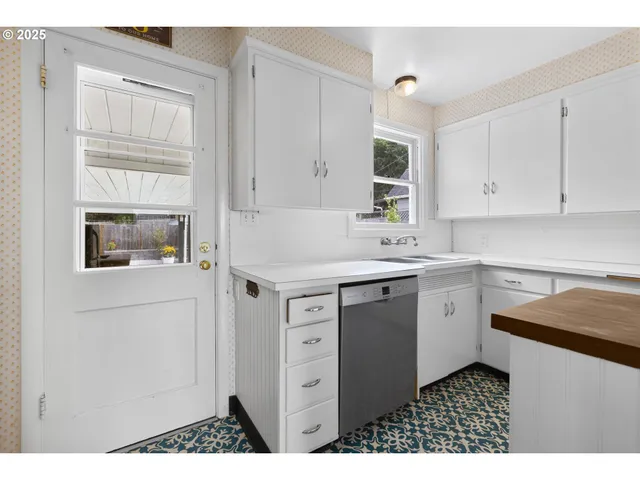 a kitchen with cabinets appliances and a window