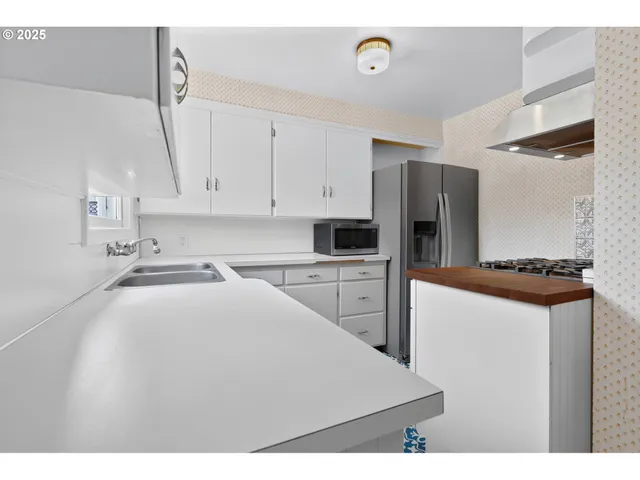 a kitchen with kitchen island a sink stainless steel appliances and cabinets