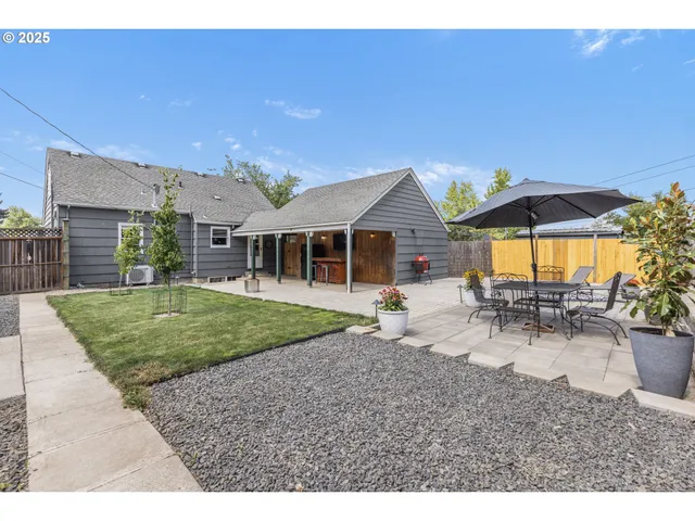 a view of a house with backyard and sitting area