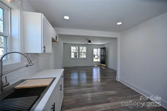 a view of a kitchen with a sink and dishwasher wooden floor