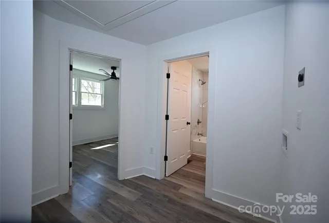 an empty room with wooden floor and a sink