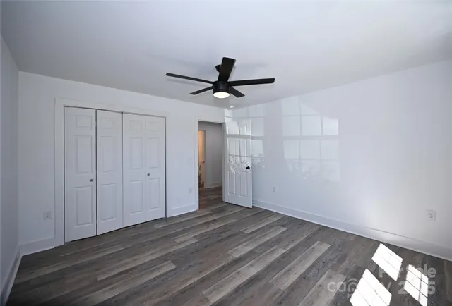 a view of a room with wooden floor and a ceiling fan
