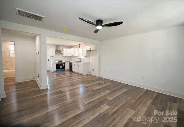 a view of empty room with wooden floor and window