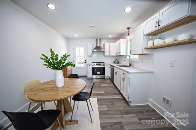 a kitchen with granite countertop kitchen island white cabinets and stainless steel appliances