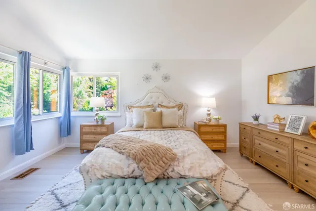 a bedroom with a bed and painting on the wall