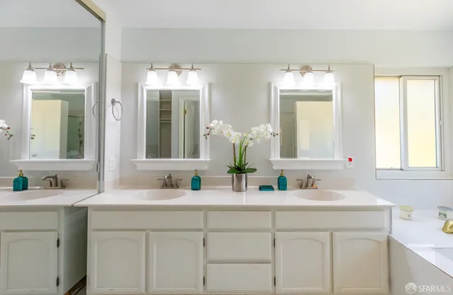 a bathroom with a granite countertop sink a mirror and a shower