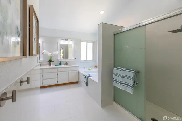 a bathroom with a granite countertop sink a mirror and a shower