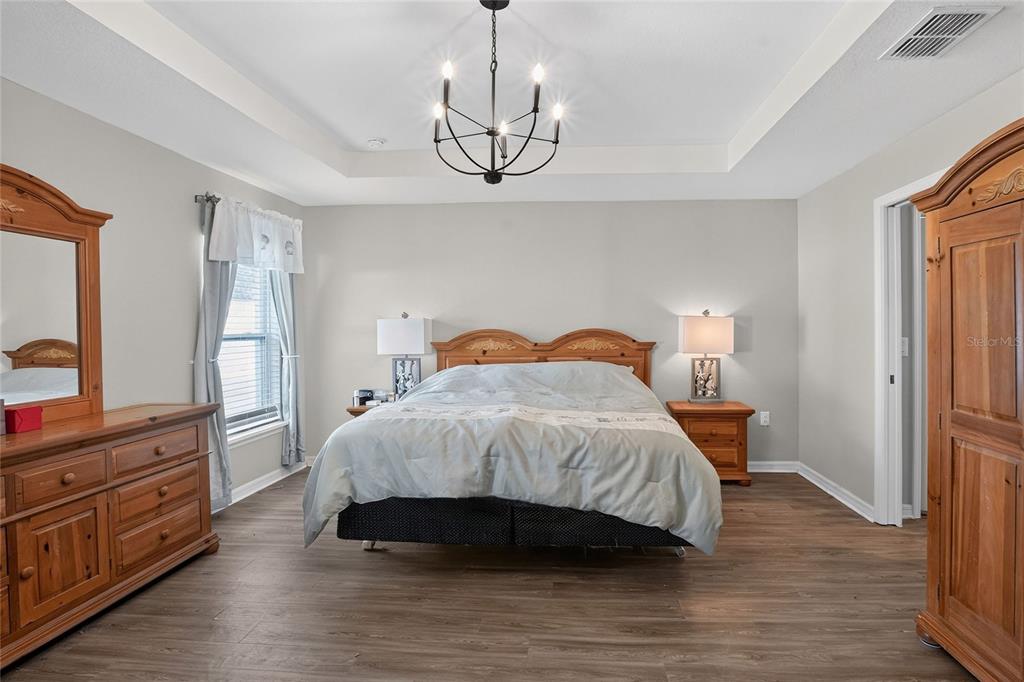 6360 Gardner Road Lakeland, FL 33813 - Photo 21 of 47 a bedroom with a bed a dresser and wooden floor