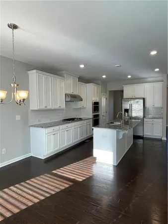 a kitchen with stainless steel appliances kitchen island granite countertop a stove a sink and a refrigerator
