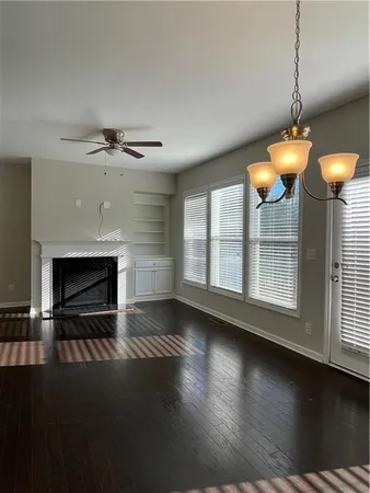 a view of a livingroom with furniture wooden floor fireplace and window