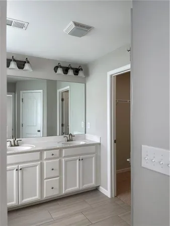 a spacious bathroom with a double vanity sink and a mirror