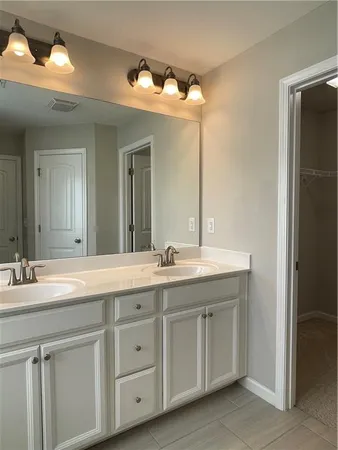 a bathroom with double sink and a mirror