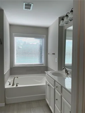a bathroom with a bathtub sink and mirror
