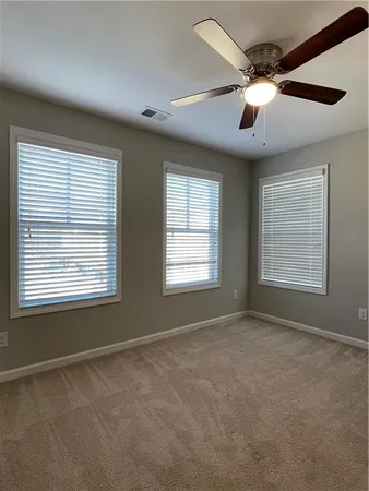 an empty room with closet and windows