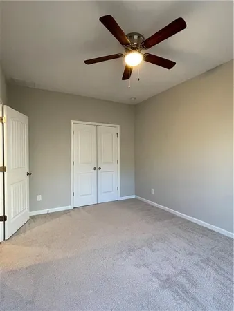 an empty room with chandelier fan