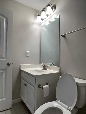 a bathroom with a granite countertop toilet sink and mirror