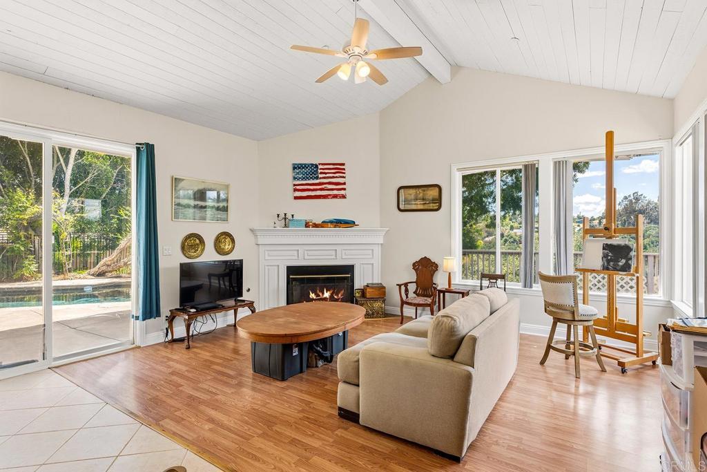 2557 Live Oak Park Road Fallbrook, CA 92028 - Photo 17 of 53 a living room with furniture a fireplace and a floor to ceiling window