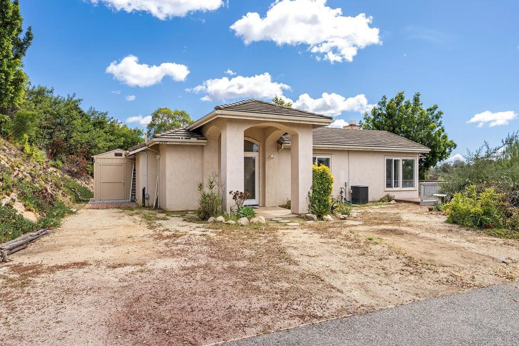 2557 Live Oak Park Road Fallbrook, CA 92028 - Photo 4 of 53 a front view of a house with a yard and garage