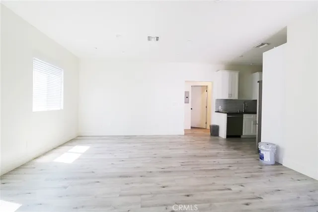 a view of empty room with wooden floor