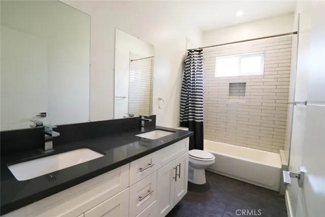 a bathroom with a granite countertop sink toilet a mirror and shower