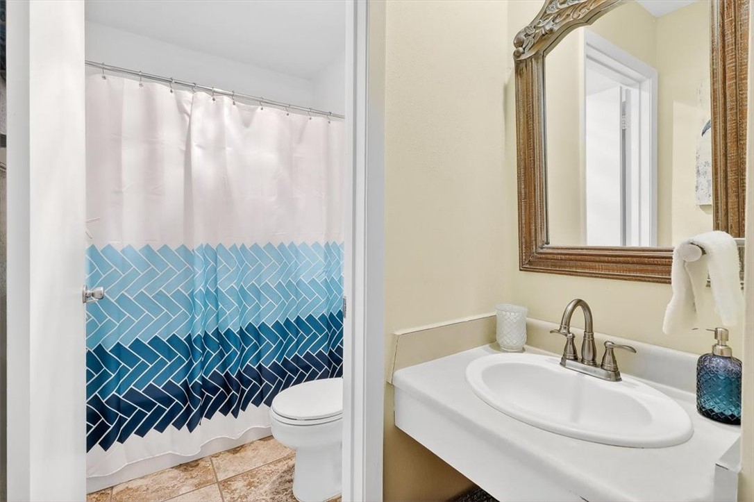 622 Beach Access Road, Unit 216 Port Aransas, TX 78373 - Photo 15 of 32 a bathroom with a toilet a sink and a mirror