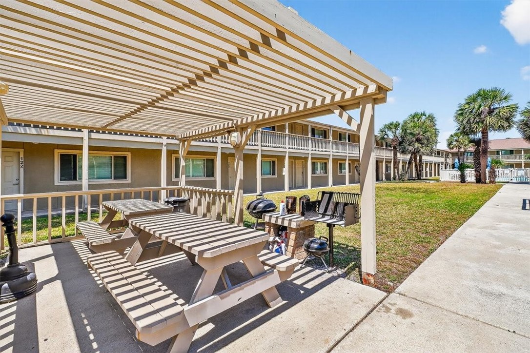 622 Beach Access Road, Unit 216 Port Aransas, TX 78373 - Photo 21 of 32 a view of a patio with table and chairs with wooden floor and fence