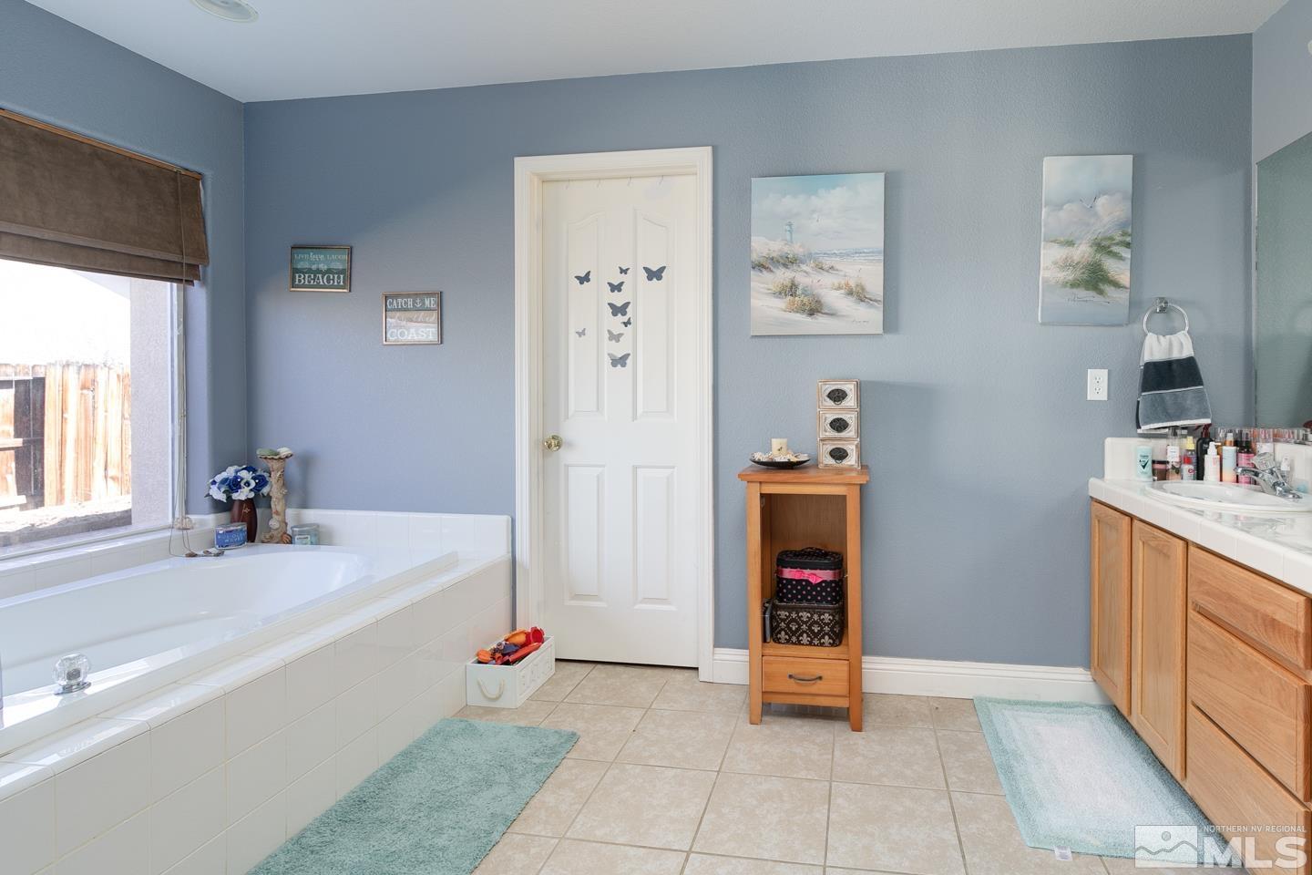 437 Rio Vista Drive Fallon, NV 89406 - Photo 11 of 24 a bathroom with a tub sink and mirror