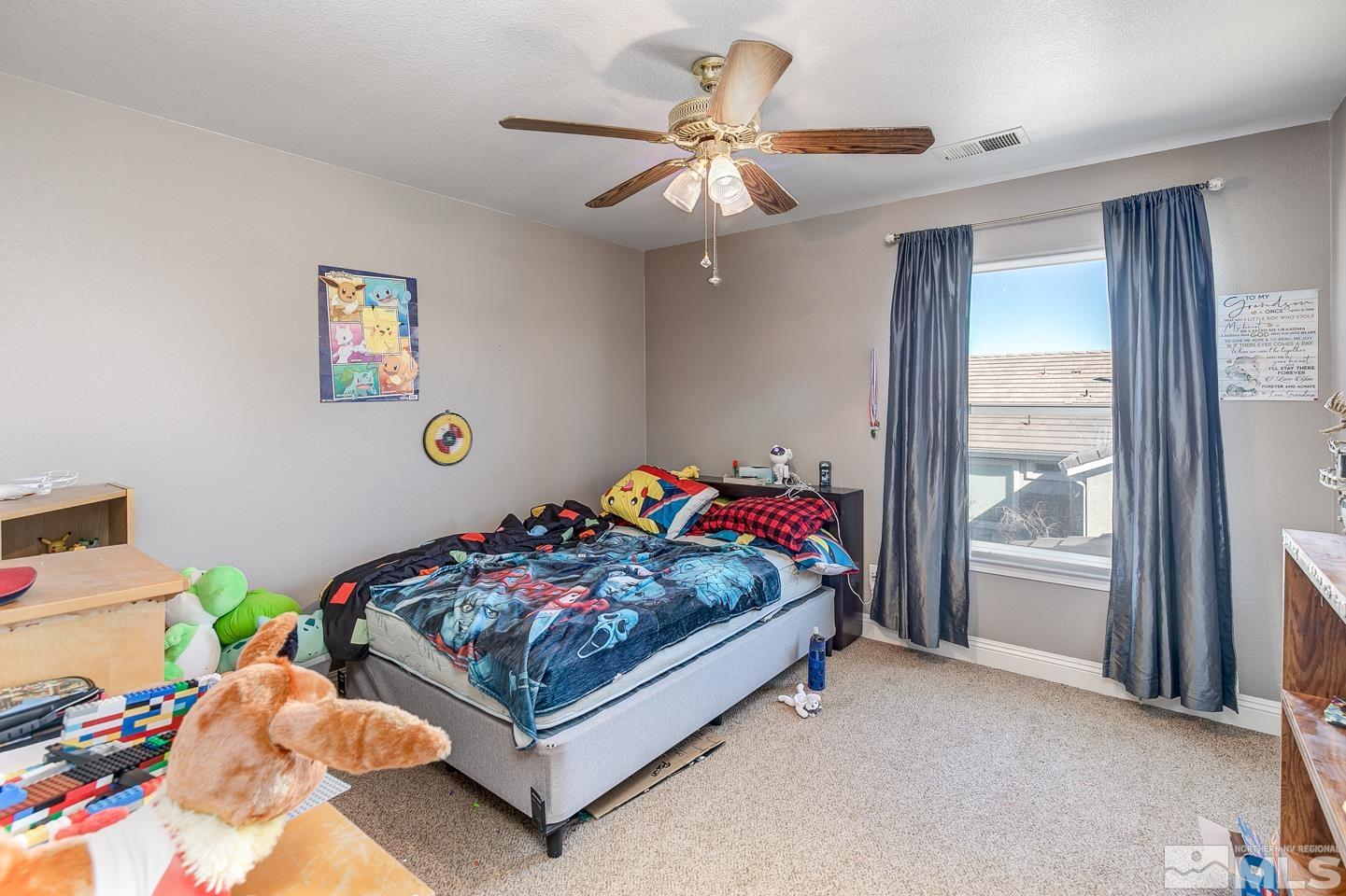 437 Rio Vista Drive Fallon, NV 89406 - Photo 15 of 24 a bedroom with a bed and a chandelier fan