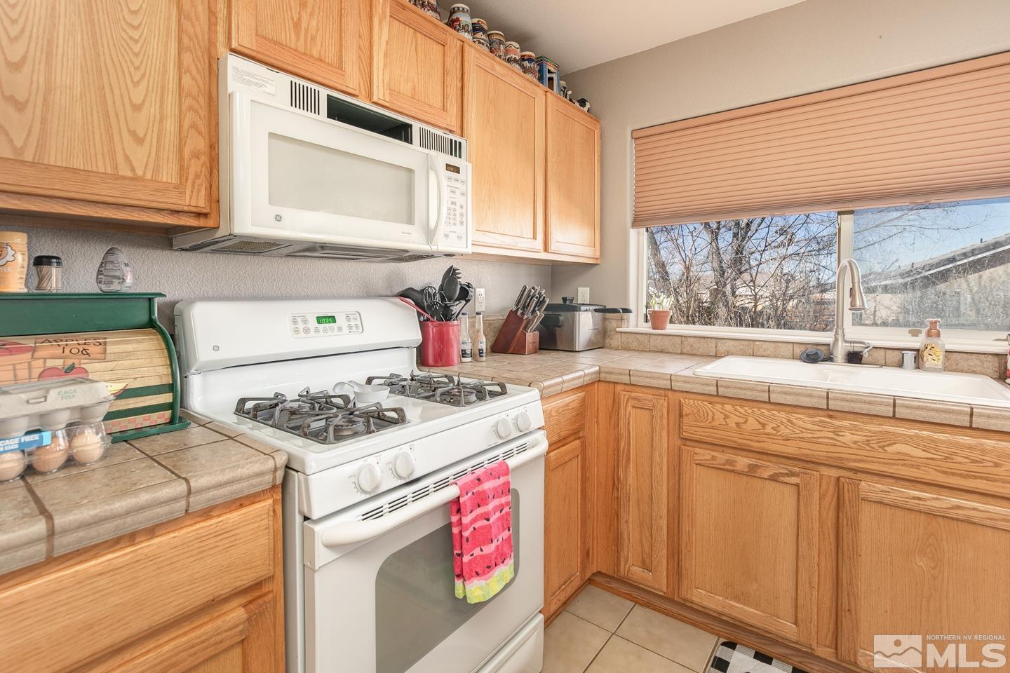 437 Rio Vista Drive Fallon, NV 89406 - Photo 8 of 24 a kitchen with stainless steel appliances granite countertop a stove and a sink
