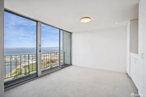 a view of kitchen with an empty space and a refrigerator