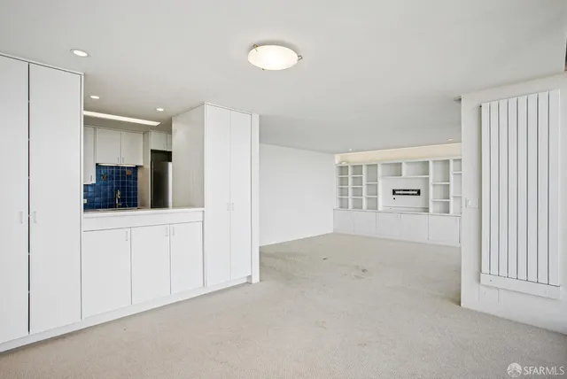a living room with a large window and walk in closet