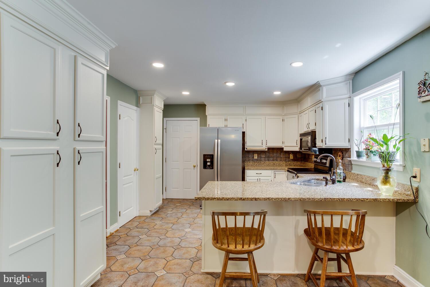 6029 Hillside Road St. Leonard, MD 20685 - Photo 4 of 15 a kitchen with stainless steel appliances granite countertop a stove a sink and a refrigerator