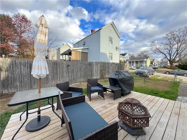 a view of a patio with table and chairs with wooden floor and fence