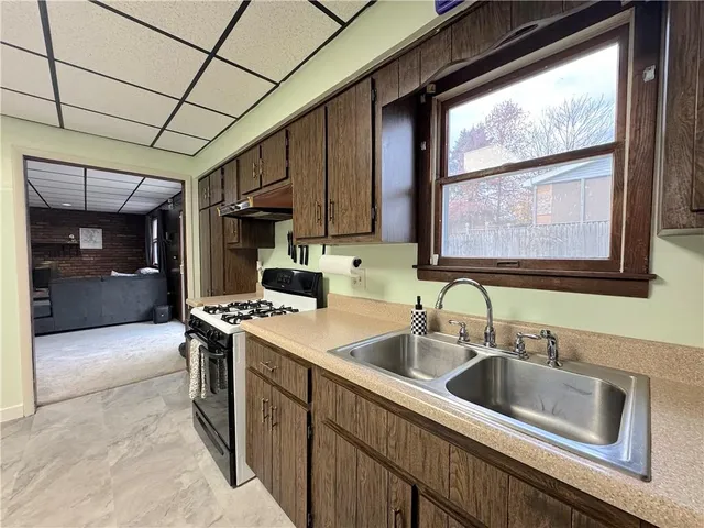 a kitchen with stainless steel appliances granite countertop a sink window and cabinets