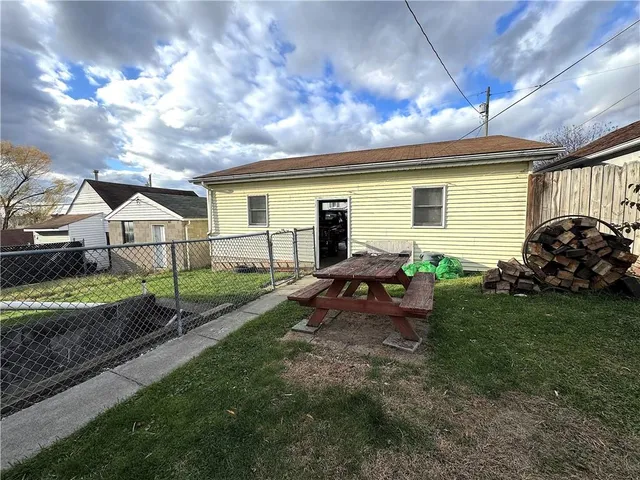 a view of backyard with house and outdoor seating