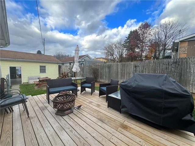 a view of a roof deck with table and chairs with wooden floor and fence