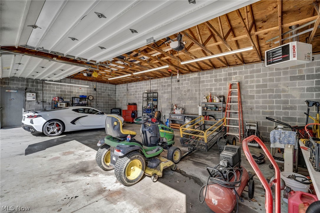 3583 West Bath Road Akron, OH 44333 - Photo 34 of 42 Spacious garage featuring concrete block walls, exposed wood beam ceiling, concrete flooring, and multiple fluorescent light fixtures