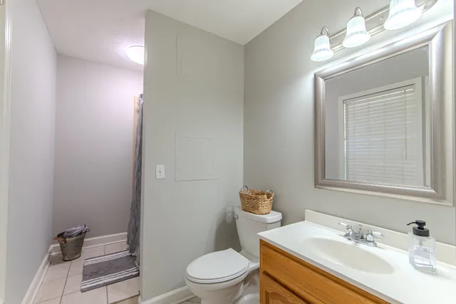a bathroom with a sink vanity mirror and toilet
