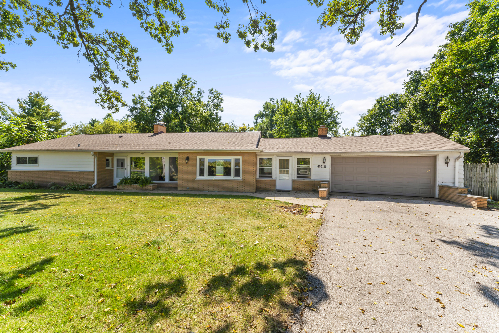 a front view of house with yard and trees around