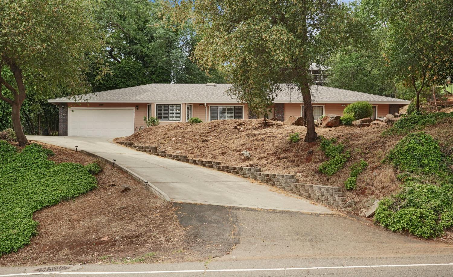 a view of a house with a yard and large trees